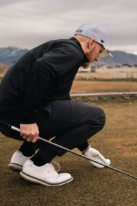 Golfer sets up his ball on the tee.