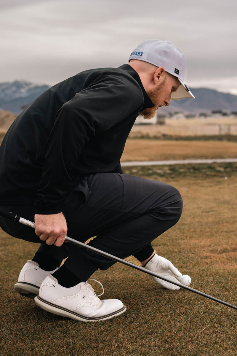 Golfer sets up his ball on the tee.